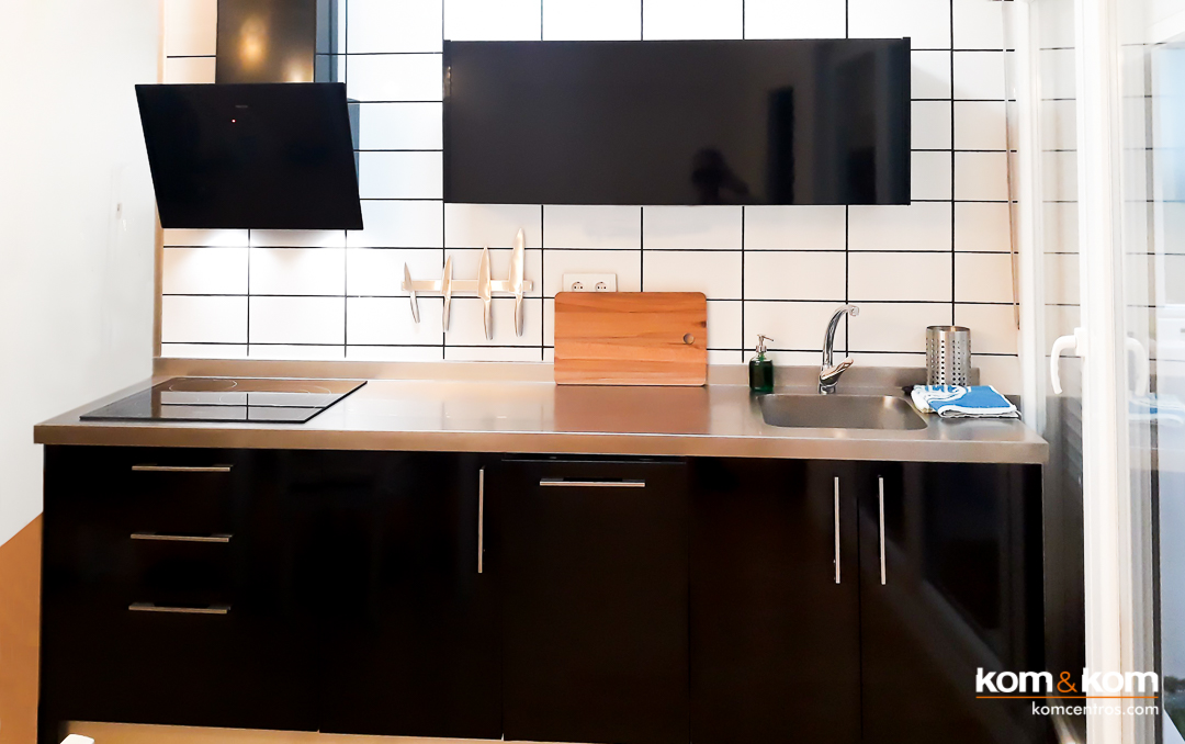 cocina peque&ntilde;a negro brillante, encimera inox, blanco mate